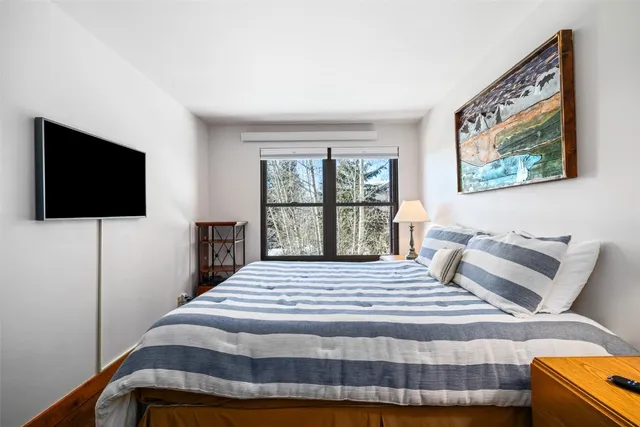 a bedroom with a bed and a flat screen tv