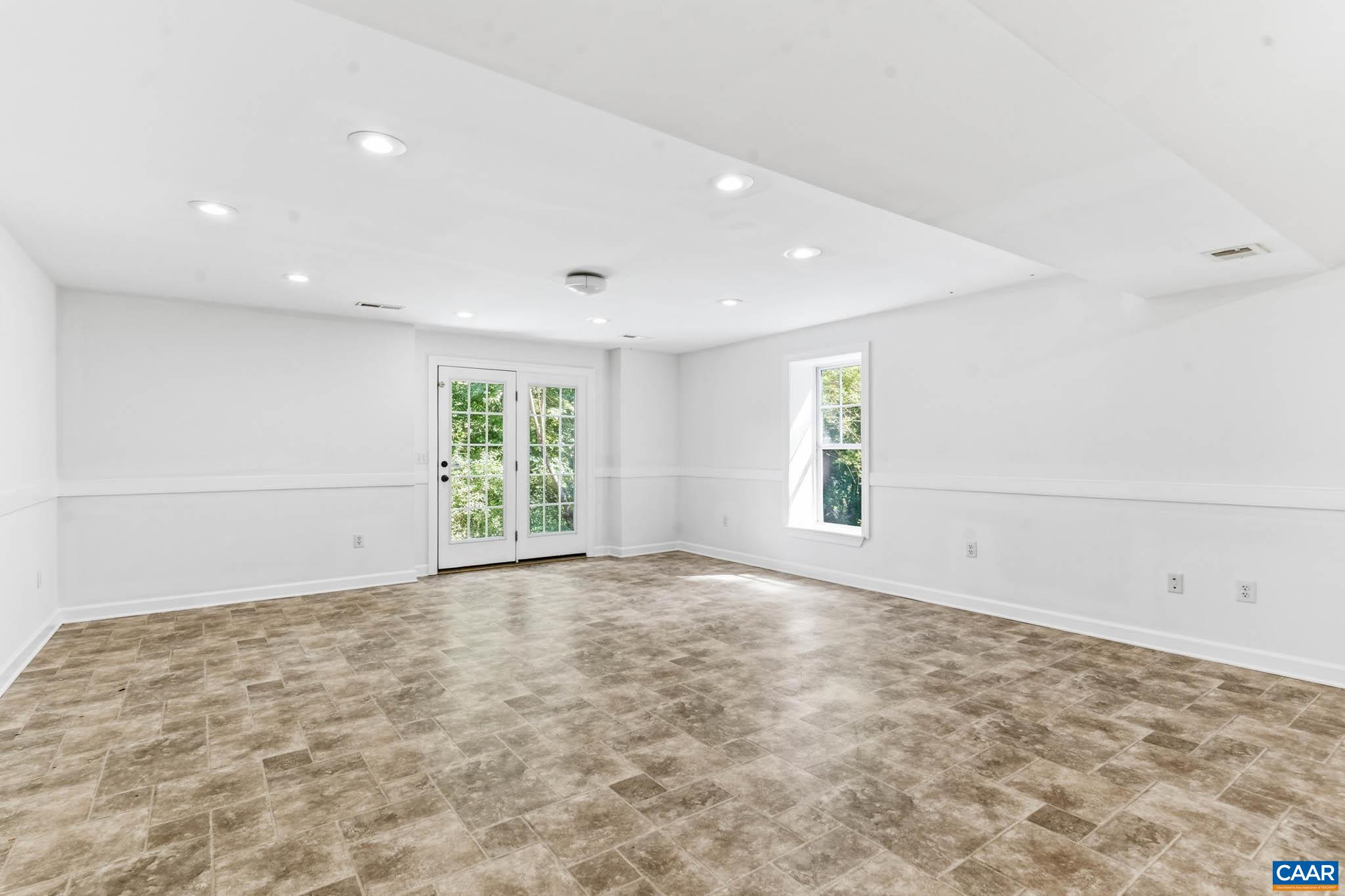 700 Rainier Road Charlottesville, VA 22903 - Photo 35 of 41 Expansive finished basement with extra tall ceilings with French doors to the rear exterior.