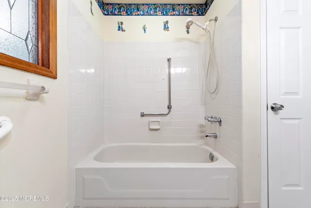 a white bath tub sitting next to a white cabinet