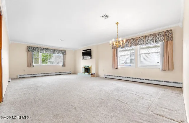 an empty room with windows and fireplace