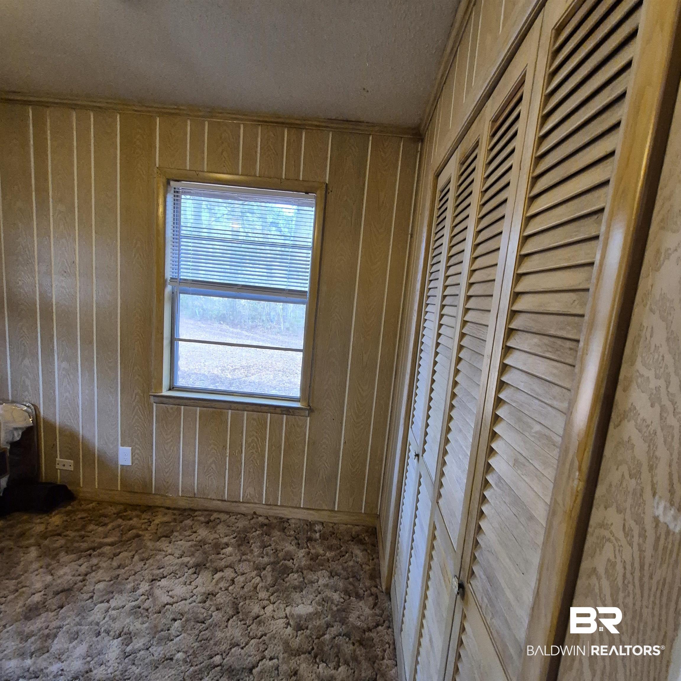 491 Forrest Avenue Castleberry, AL 36432 - Photo 17 of 33 Unfurnished bedroom with baseboards and wooden walls