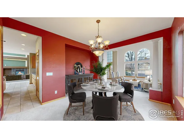a dining room with wooden floor a chandelier a wooden table and chairs