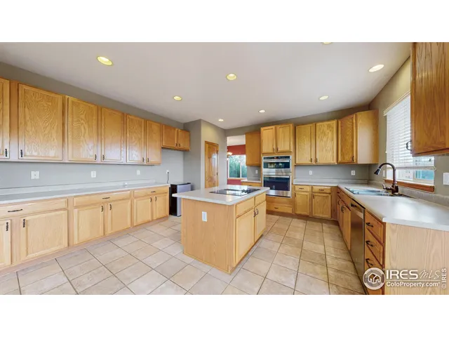 a kitchen with stainless steel appliances kitchen island granite countertop a sink counter space cabinets and a large window
