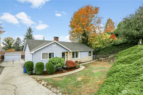 a view of a house with a big yard plants and large trees