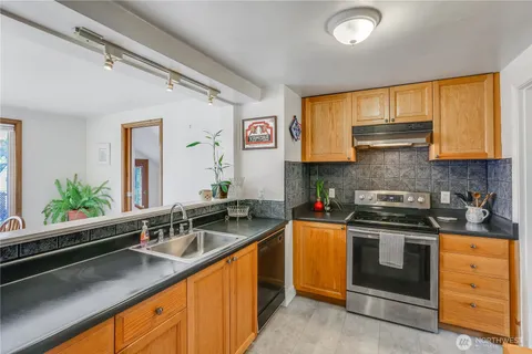 a kitchen with stainless steel appliances granite countertop a sink stove and cabinets