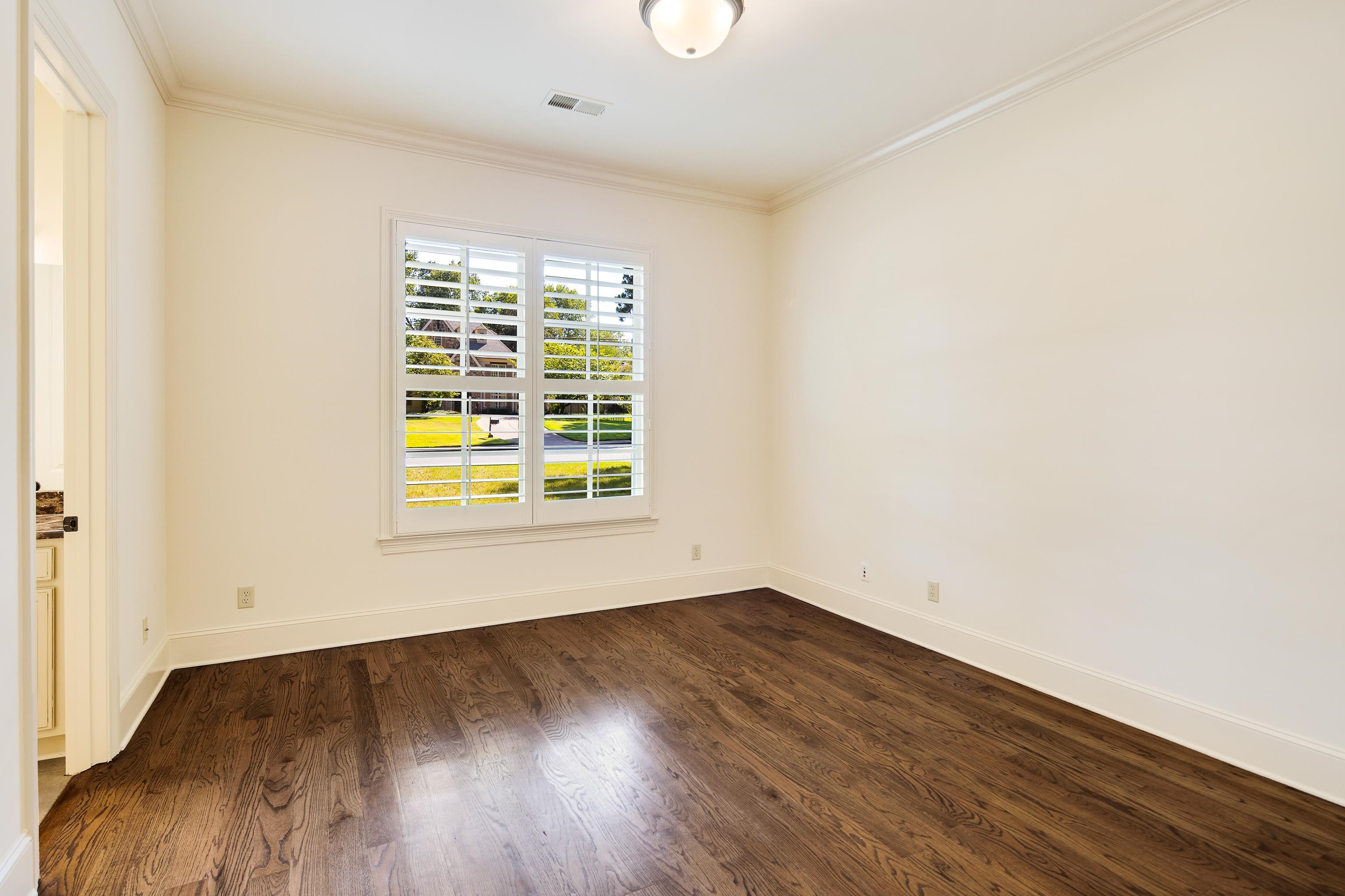 4938 Barfield Road Memphis, TN 38117 - Photo 17 of 40 an empty room with wooden floor and windows