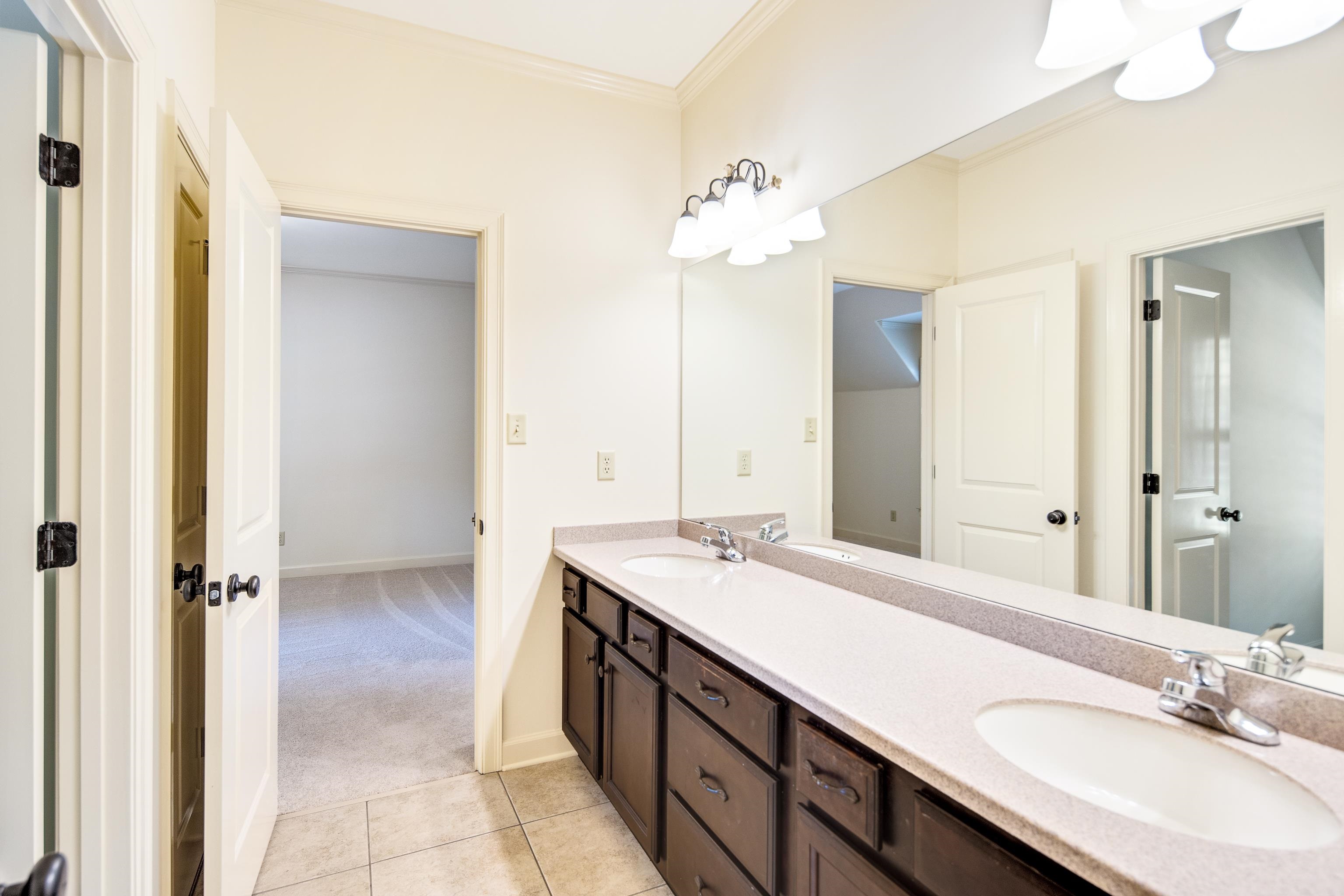 4938 Barfield Road Memphis, TN 38117 - Photo 23 of 40 a bathroom with a double vanity sink a mirror and a shower