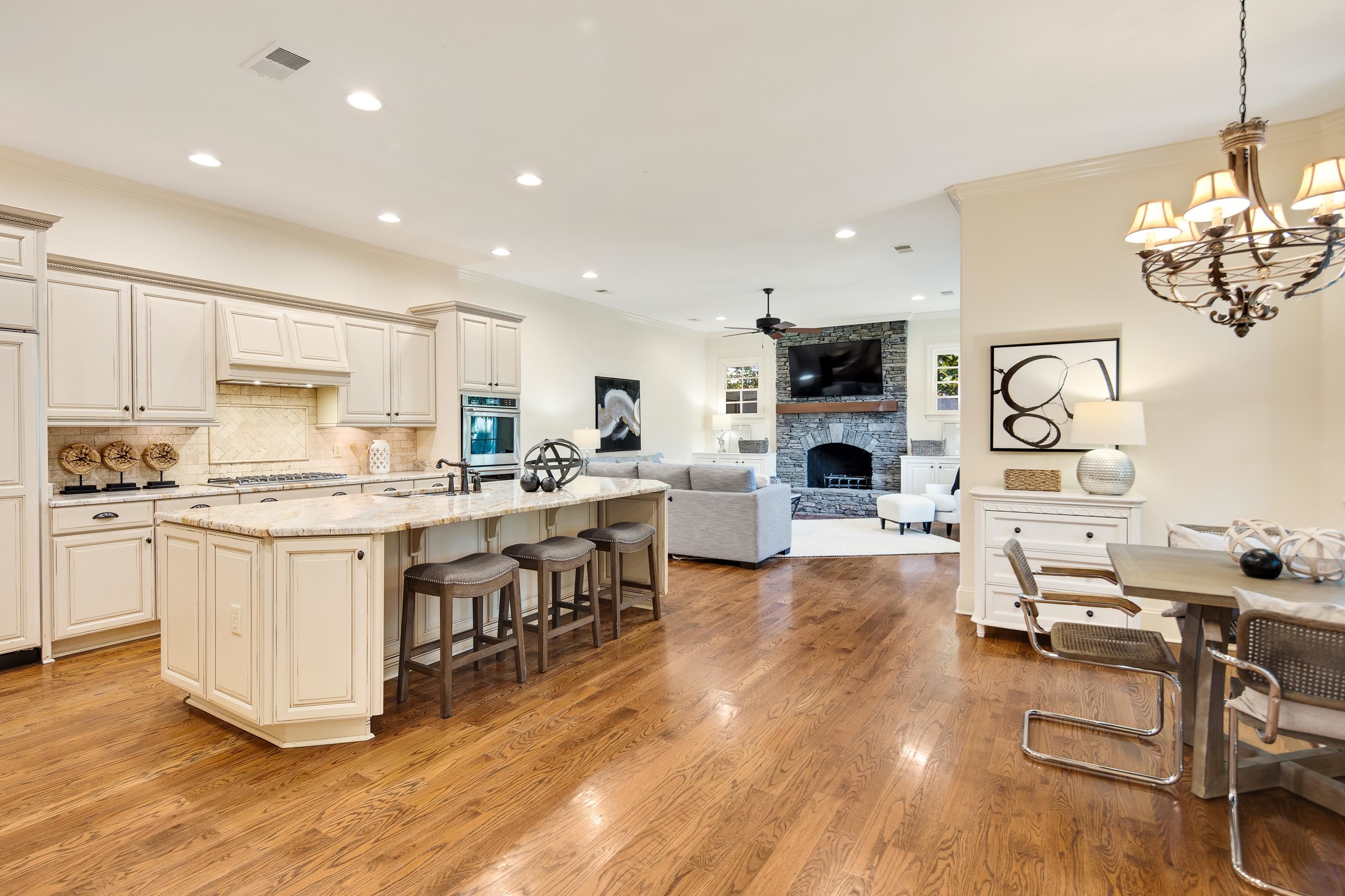 4938 Barfield Road Memphis, TN 38117 - Photo 9 of 40 a kitchen with stainless steel appliances granite countertop a stove top oven a sink a dining table and chairs with wooden floor