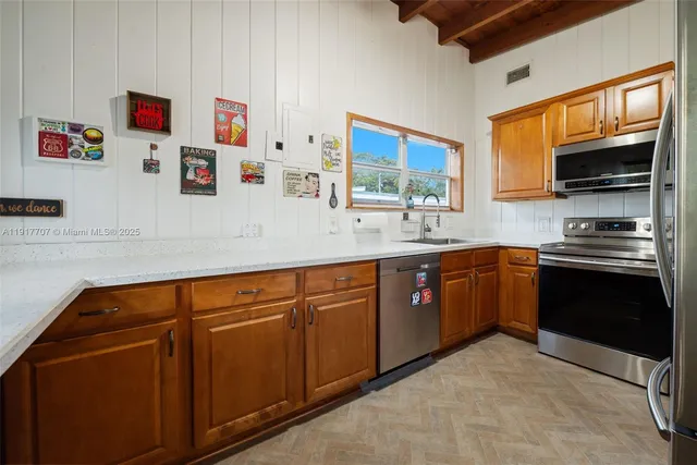 a kitchen with stainless steel appliances granite countertop a refrigerator and a sink