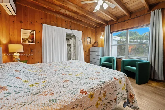 a bedroom with a bed and a dresser next to a window