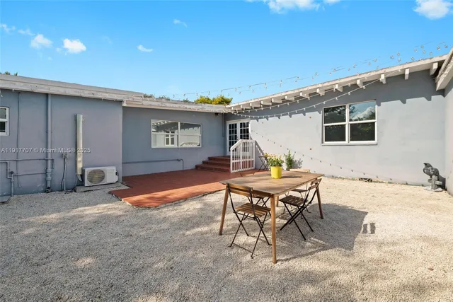 a backyard of a house with table and chairs
