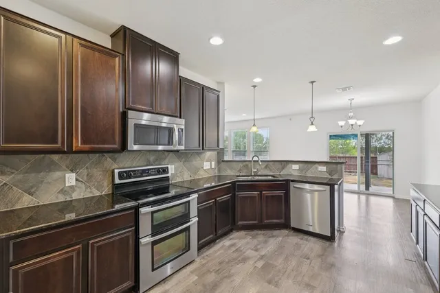 a kitchen with stainless steel appliances granite countertop a sink and stove top oven