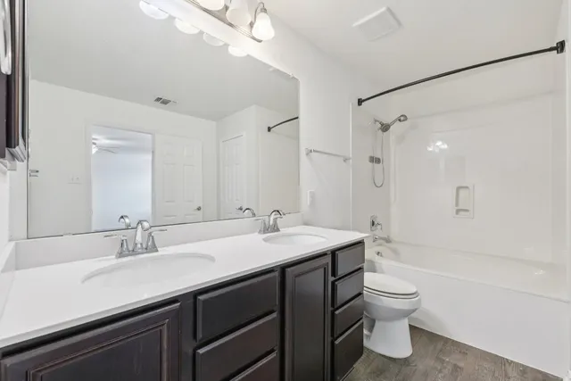 a bathroom with a sink toilet a mirror and shower