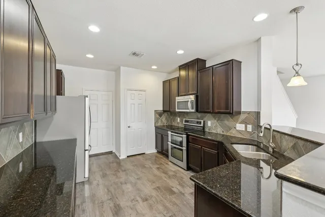 a kitchen with a sink stove and refrigerator