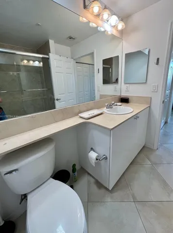 a bathroom with a sink a large mirror and vanity
