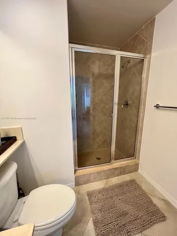 a bathroom with a sink a toilet a mirror and shower
