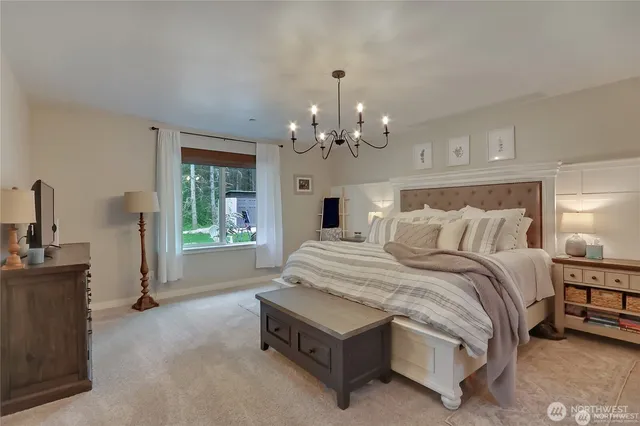 a spacious bedroom with bed and a chandelier