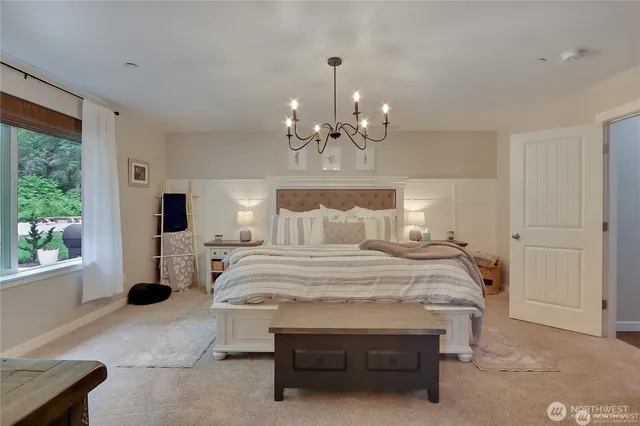 a bedroom with a large bed and a chandelier