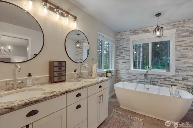 a bathroom with a granite countertop double vanity sink and a mirror