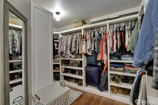 a view of walk in closet with clothes and shoes