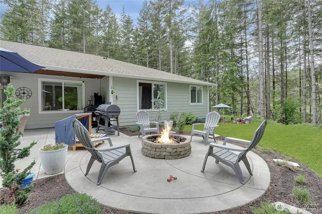a view of a patio with table and chairs potted plants with large tree