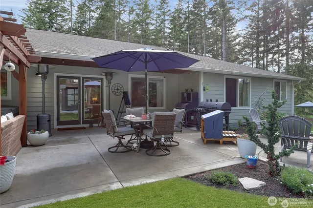 a view of a patio with table and chairs under an umbrella