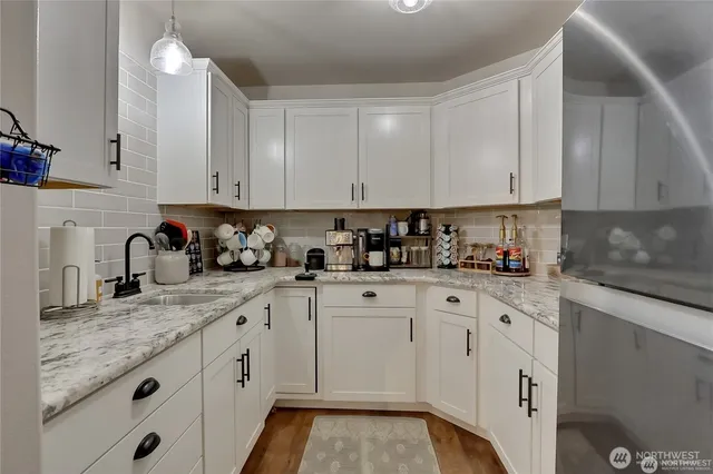 a kitchen with granite countertop white cabinets and white appliances