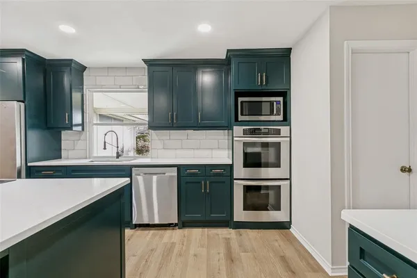 a kitchen with stainless steel appliances granite countertop a refrigerator and a stove top oven