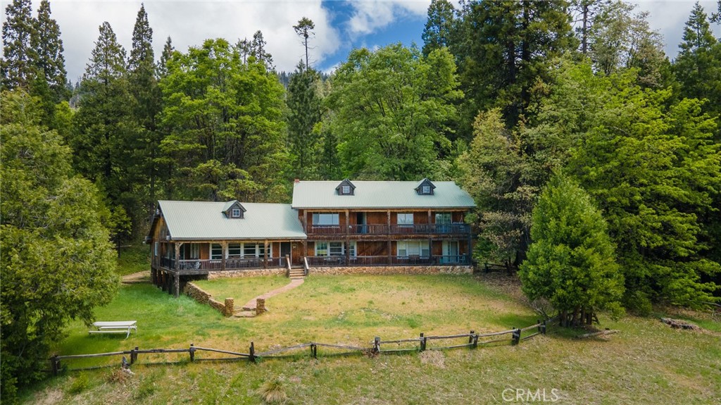 aerial view of a house with swimming pool and large trees