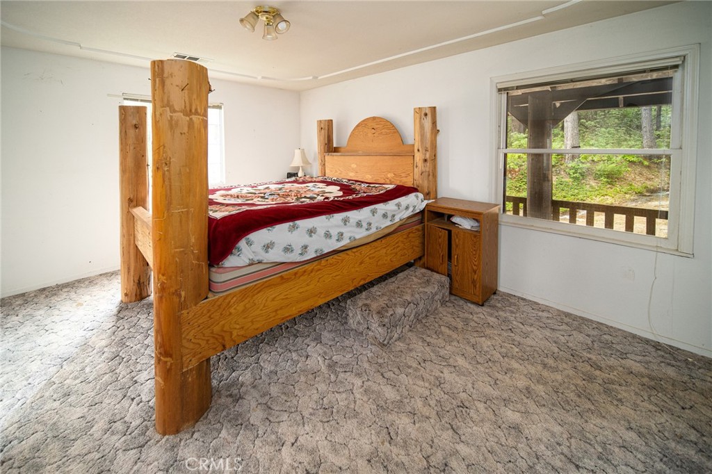 5657 Worman Road Ahwahnee, CA 93601 - Photo 22 of 40 a bedroom with a bed and wooden floor