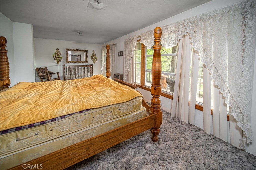 5657 Worman Road Ahwahnee, CA 93601 - Photo 23 of 46 a bed sitting in a bedroom next to a window