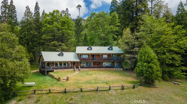 aerial view of a house with swimming pool and large trees