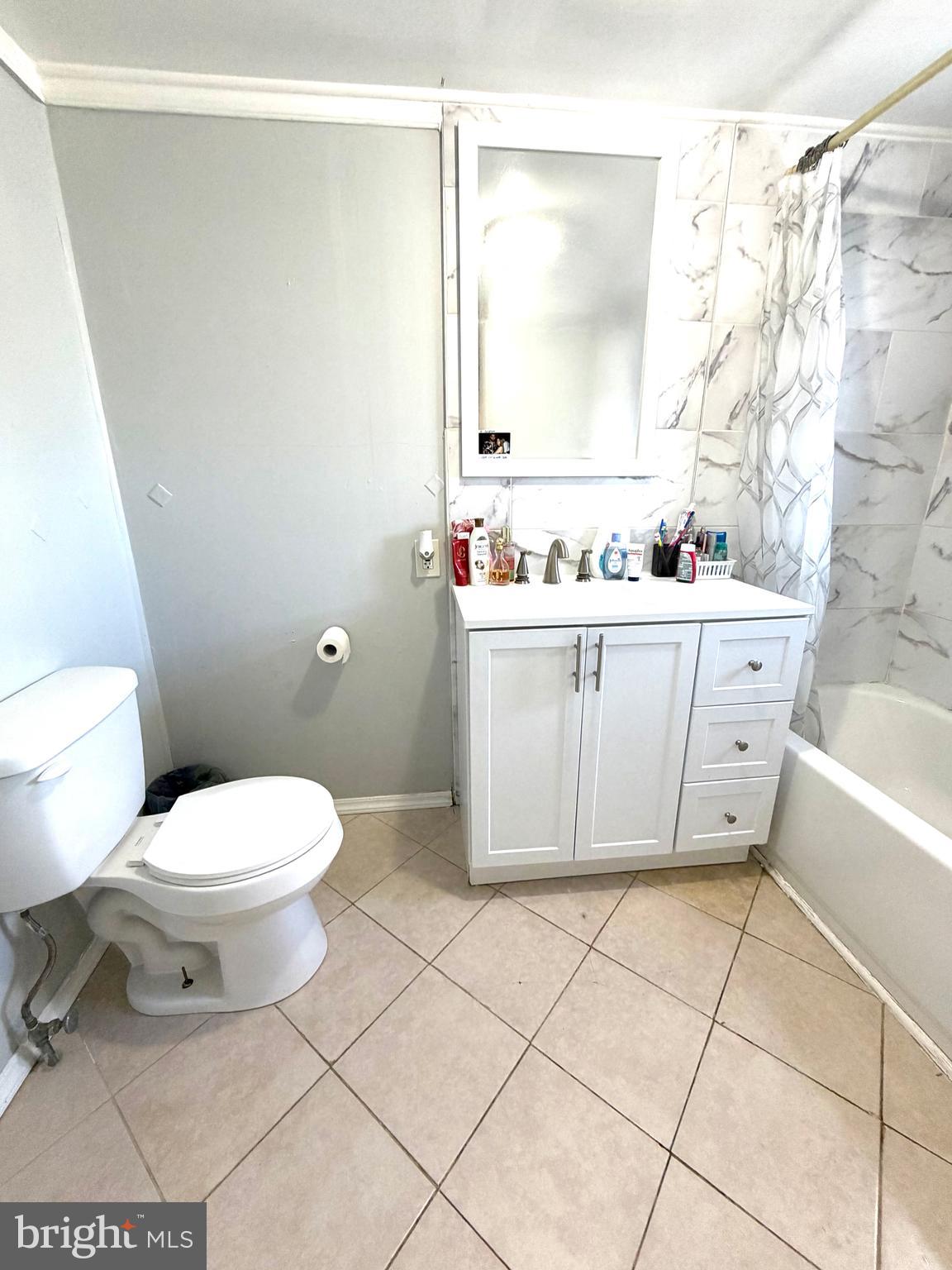 526 South 11th Street Reading, PA 19602 - Photo 14 of 22 a bathroom with a granite countertop sink a toilet and a mirror