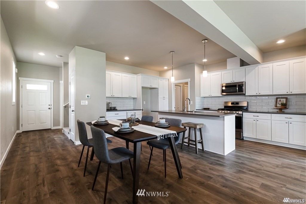 6902 Red Ridge Drive, Unit A Lynden, WA 98264 - Photo 6 of 31 a kitchen with a table chairs a sink dishwasher refrigerator and cabinets