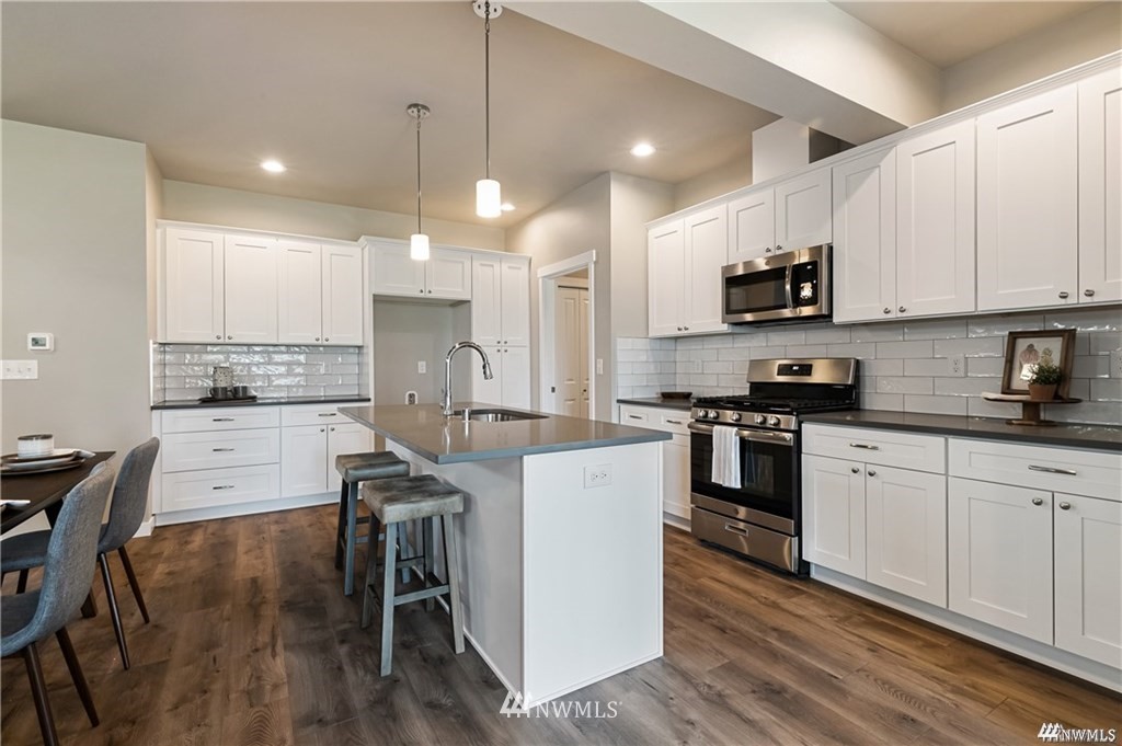 6902 Red Ridge Drive, Unit A Lynden, WA 98264 - Photo 8 of 31 a kitchen with kitchen island granite countertop a sink a counter space stainless steel appliances and cabinets