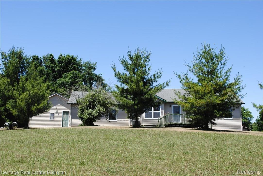 4354 Crandall Road Howell, MI 48855 - Photo 11 of 17 Rear view of this rambling ranch with a large deck sheltered by towering trees!