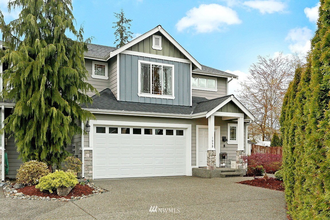 a view of a house with a yard and potted plants