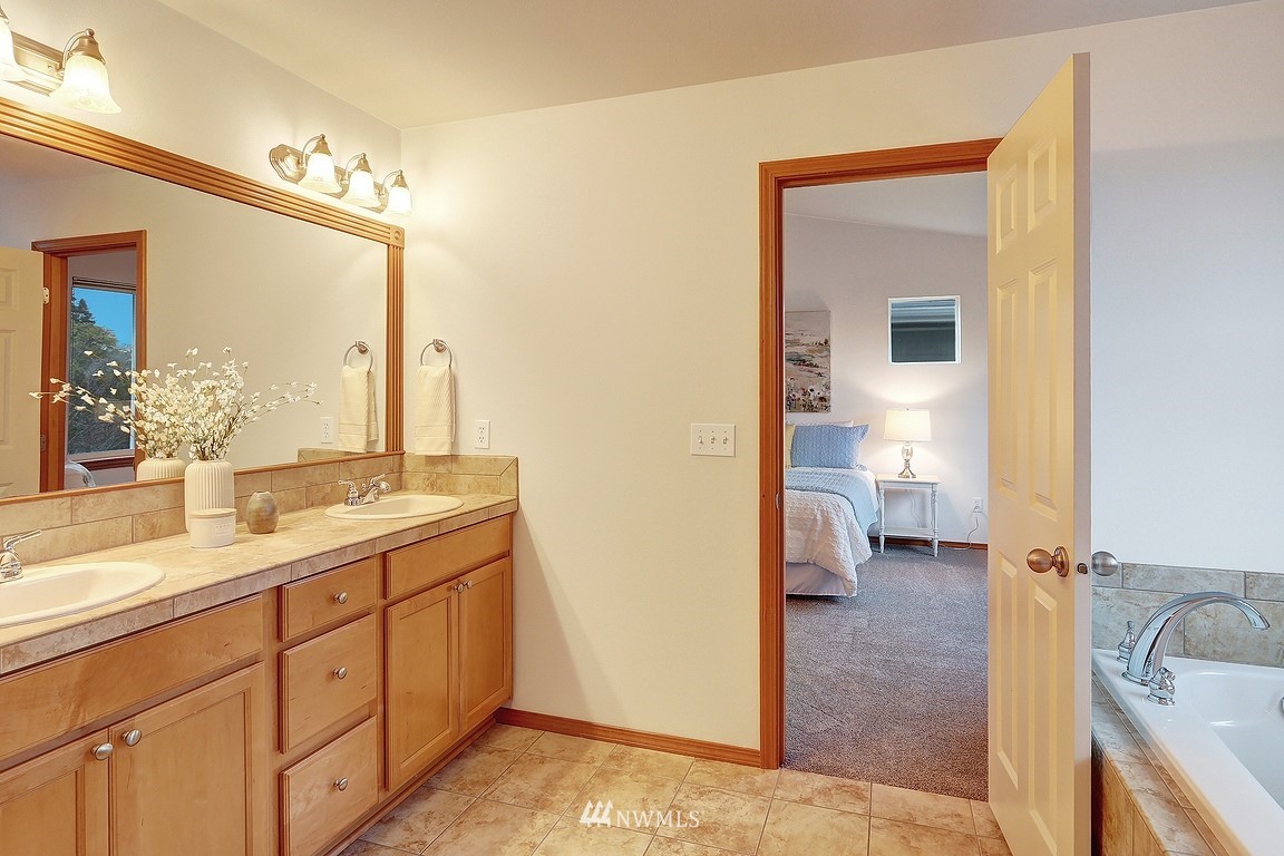 105 182nd Place Southwest, Unit B Bothell, WA 98012 - Photo 18 of 25 a spacious bathroom with a double vanity sink a mirror and a toilet
