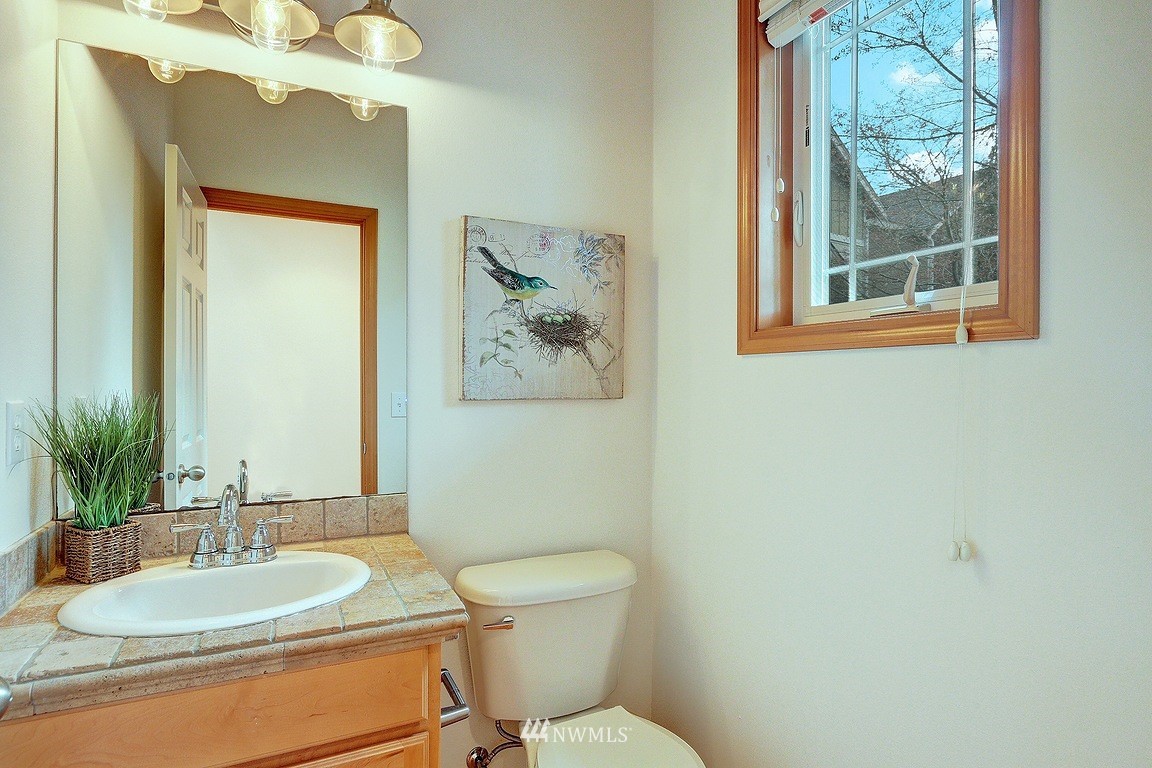 105 182nd Place Southwest, Unit B Bothell, WA 98012 - Photo 3 of 25 a bathroom with a granite countertop toilet a sink and mirror
