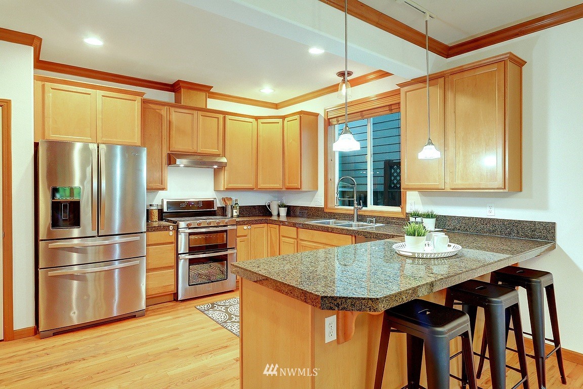 105 182nd Place Southwest, Unit B Bothell, WA 98012 - Photo 8 of 25 a kitchen with granite countertop a sink appliances cabinets and counter space