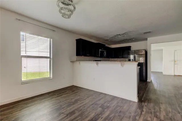 a view of empty room with wooden floor and window