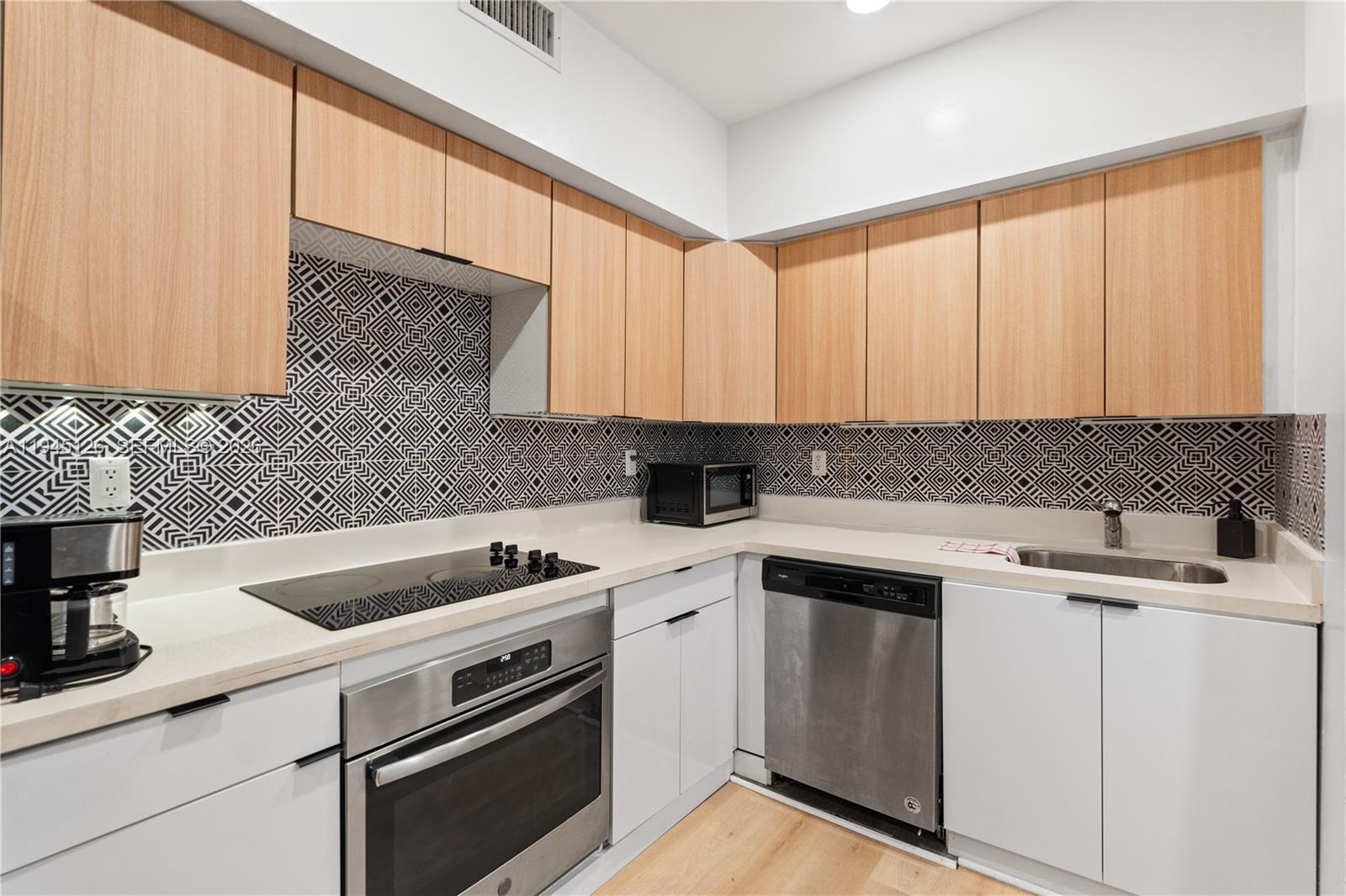 810 7th Street, Unit 102 Miami Beach, FL 33139 - Photo 1 of 21 a kitchen with a sink stove and cabinets