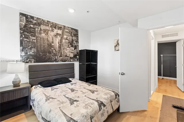 a bedroom with a bed and wooden floor