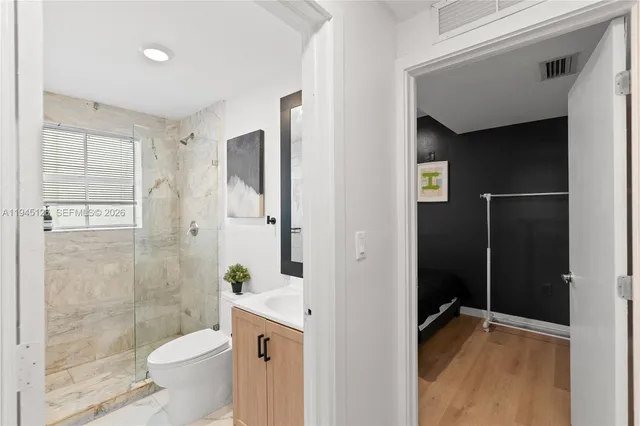 a bathroom with a granite countertop sink toilet and shower