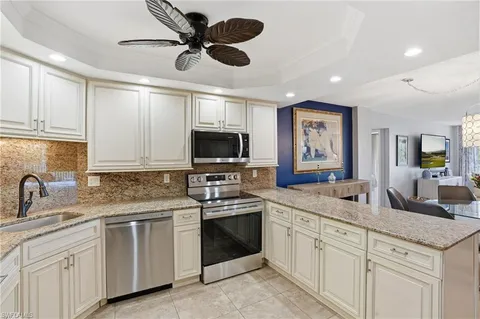 a kitchen with stainless steel appliances granite countertop a sink refrigerator and cabinets