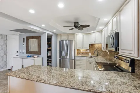 a kitchen with stainless steel appliances granite countertop a refrigerator a sink a stove top oven a sink and dishwasher