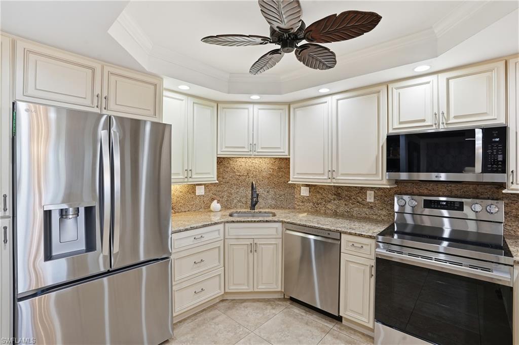 5 Bluebill Avenue, Unit 301 Naples, FL 34108 - Photo 16 of 48 a kitchen with stainless steel appliances a refrigerator sink and microwave