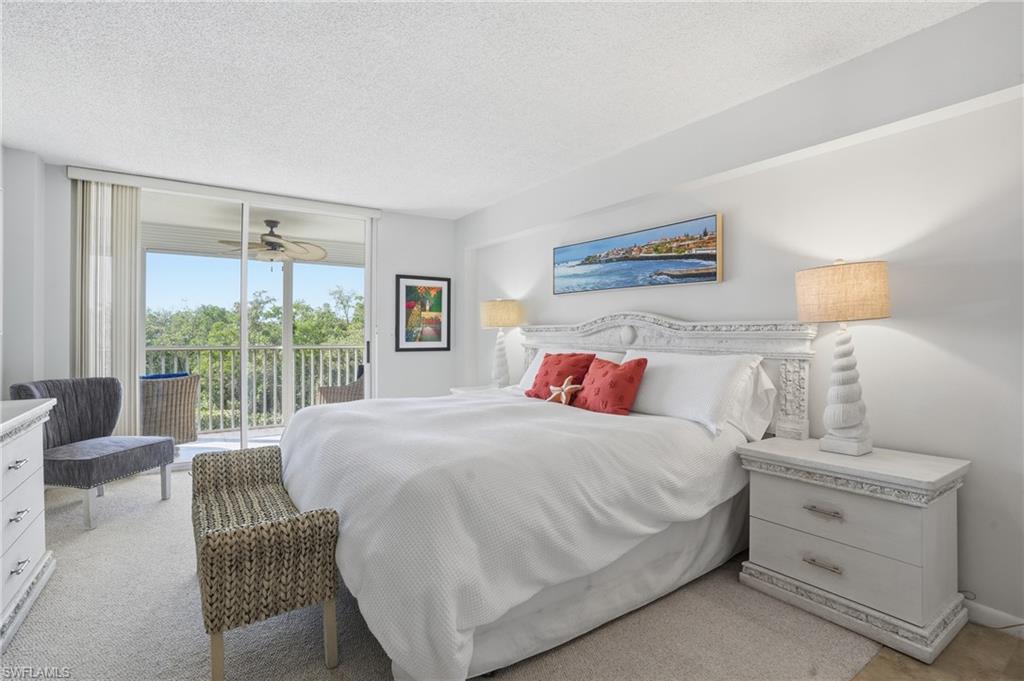 5 Bluebill Avenue, Unit 301 Naples, FL 34108 - Photo 18 of 48 a bedroom with a bed and a large window