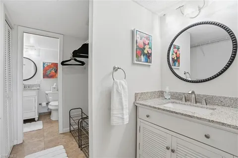 a bathroom with a granite countertop toilet sink and mirror