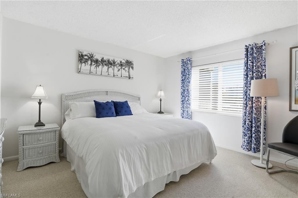 5 Bluebill Avenue, Unit 301 Naples, FL 34108 - Photo 24 of 48 a bedroom with a bed and a lamp